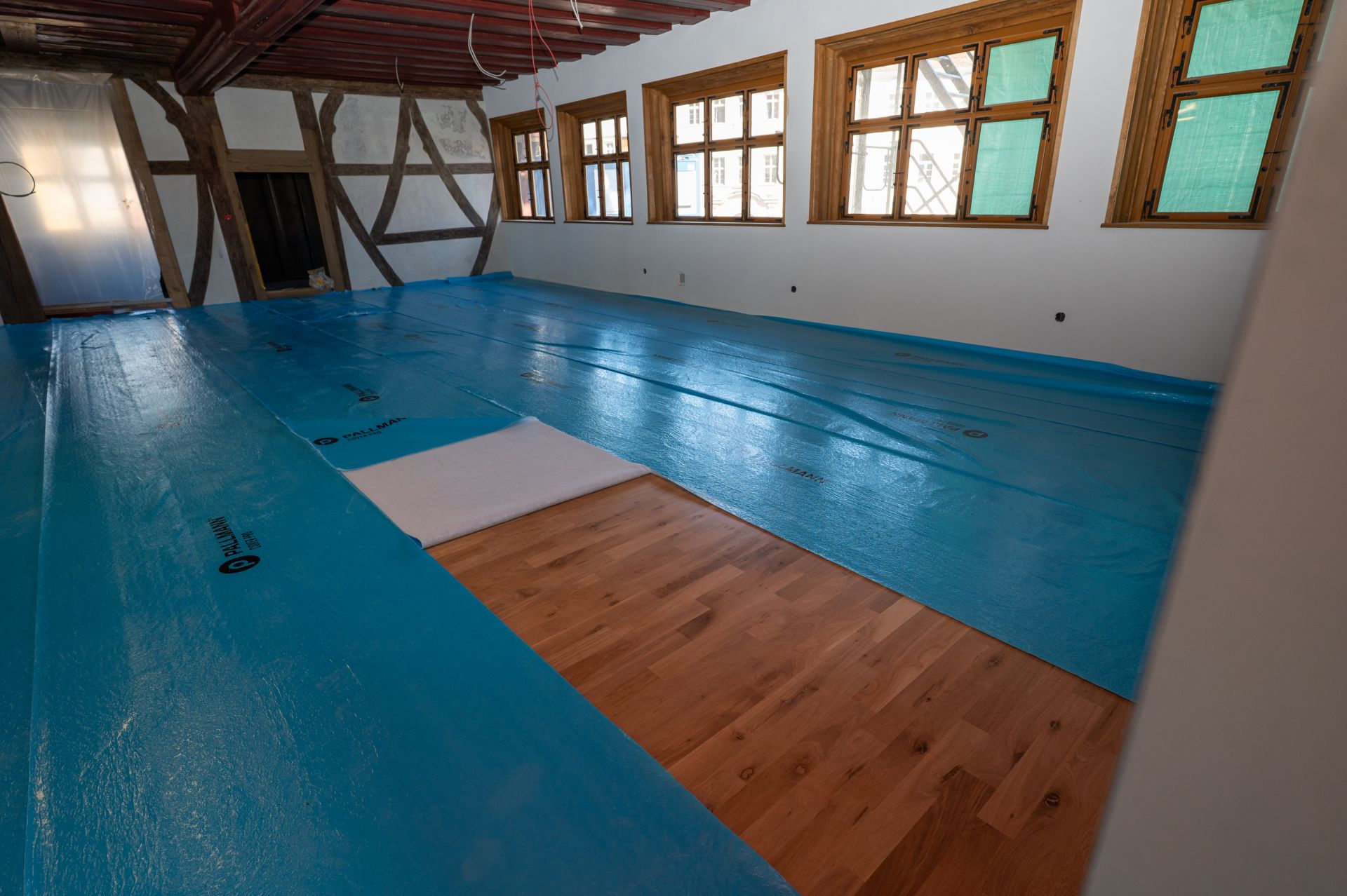 Parkettarbeiten im Magistratsbau Die Parkettarbeiten im Magistratsbau wurden zum Schutz vor Abrieb noch mit blauen Planen abgedeckt.