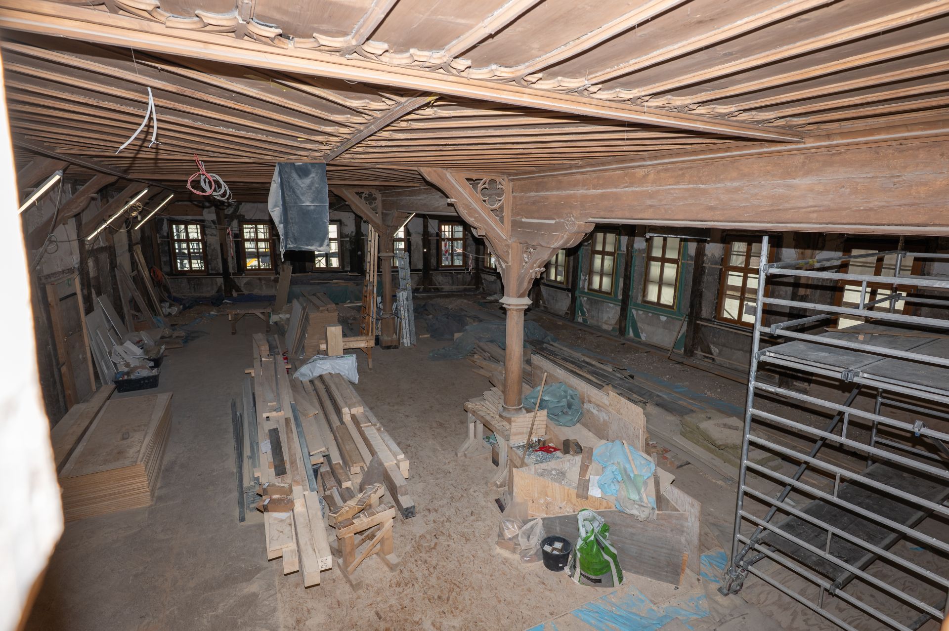 Die restauratorischen Arbeiten an Decke und Lambrie des großen Rathaussaals haben begonnen. Die restauratorischen Arbeiten an Decke und Lambrie des großen Rathaussaals haben begonnen. Im Raum befindet sich verschiedenes Baumaterial aus Holz, Leitern und ein Gerüst. Der Raum wirkt noch entkernt, viele Bauarbeiten stehen hier noch aus.