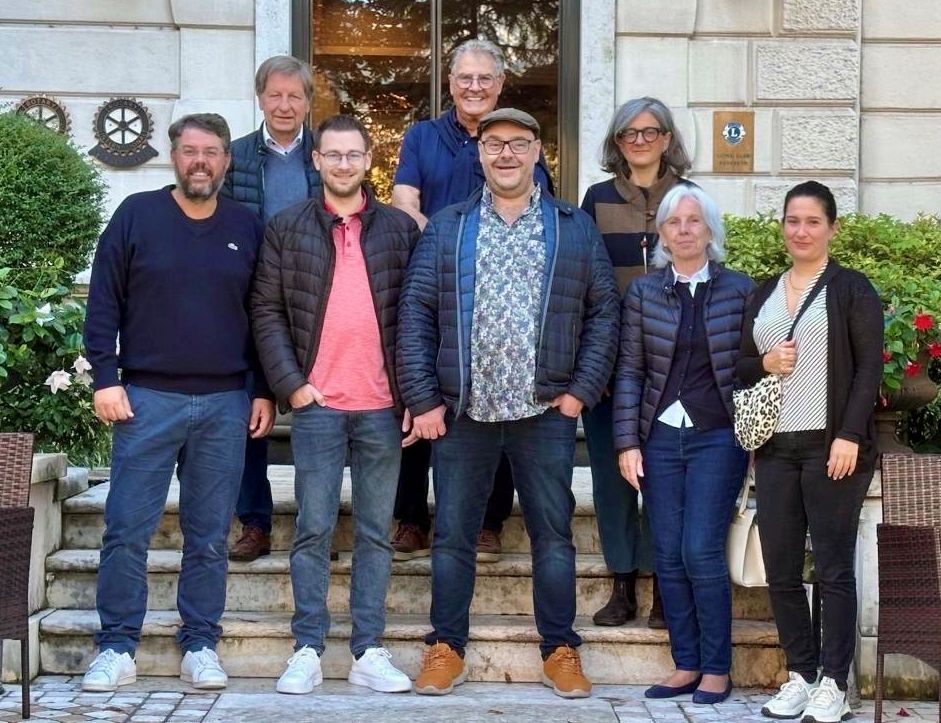 100. Jubiläum der Friedenglocke in Rovereto Forchheimer Delegation mit Vertreter der Partnerstadt Rovereto vor einem Gebäude umrahmt von begrünten Pflanzkübeln.