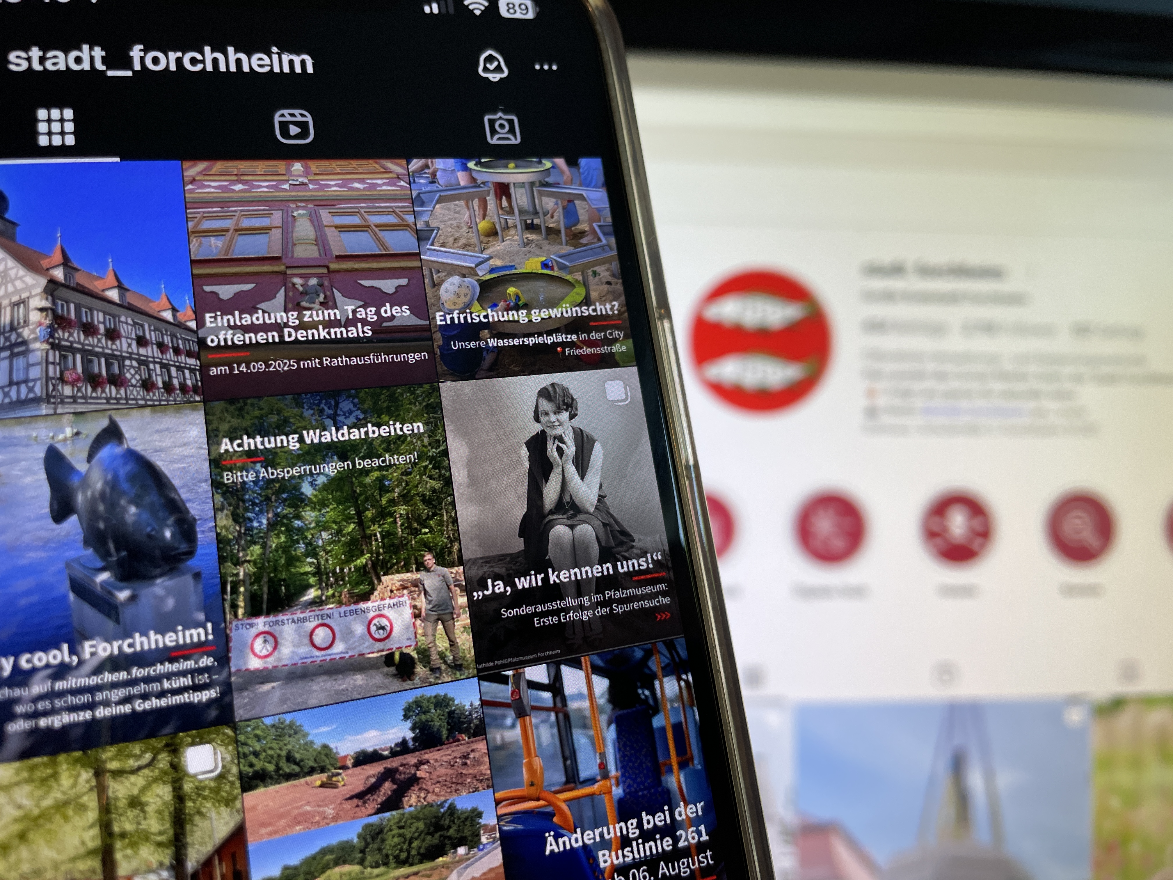 Ein Instagram Feed auf einem Handy sowie im Hintergrund eine verschwommene Profilansicht des Instagram Account der Stadt Forchheim