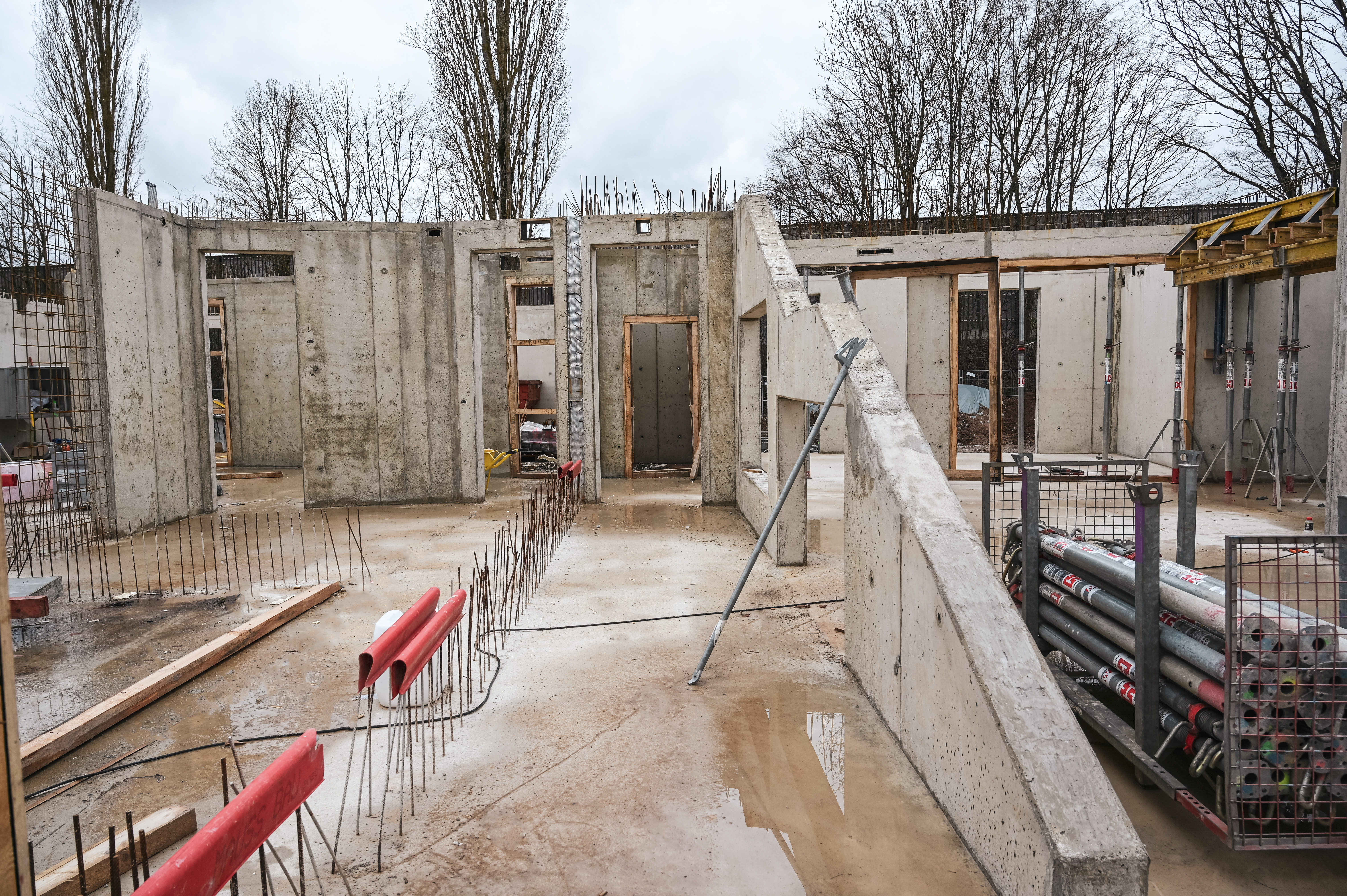 Eine Großbaustelle im Rohbau. Im Erdgeschoss werden Betonwände errichtet.